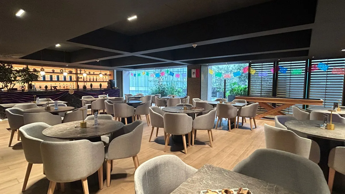 Comedor montado antes del servicio, con mesas y sillas dispuestas